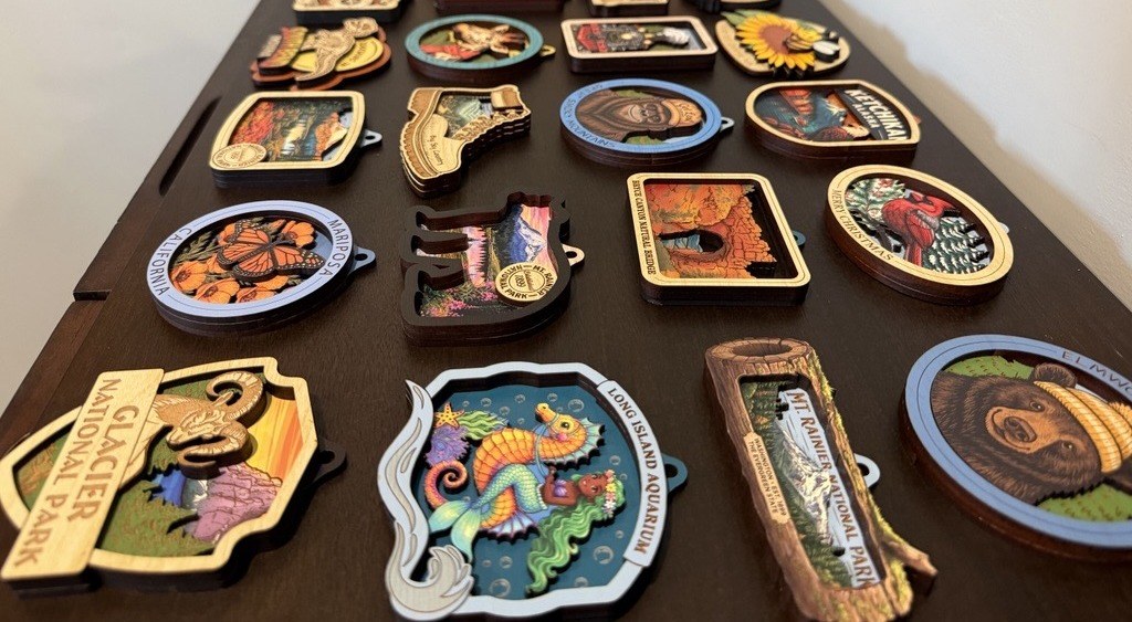 A table of finished Tim Weberding Woodworking laser-engraved wood ornaments and magnets in the workshop
