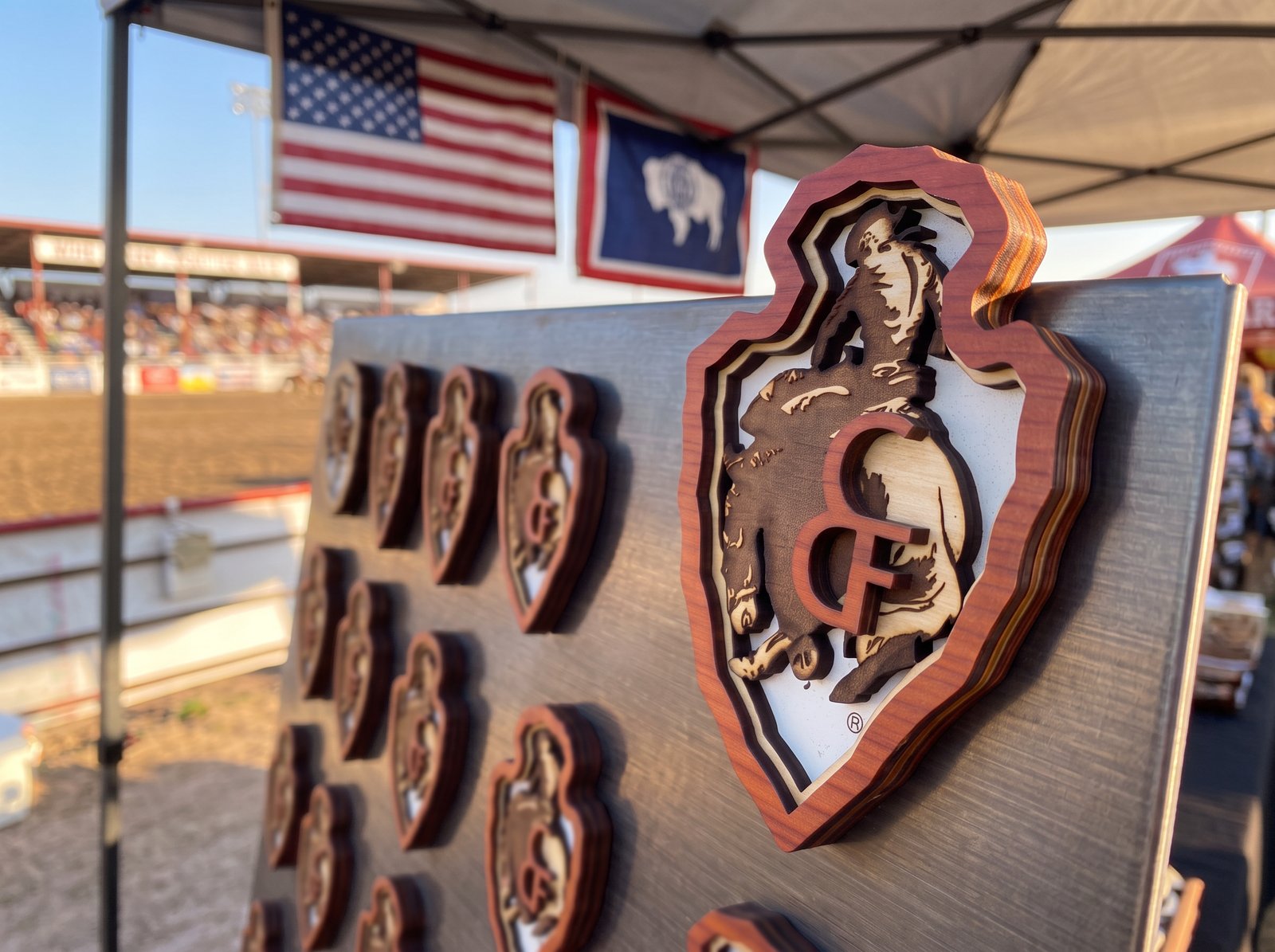 Custom wood arrowhead-shaped piece featuring a bucking bronco rider for the C&F rodeo event
